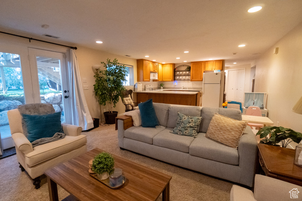 Living room with a wealth of natural light and light colored carpet