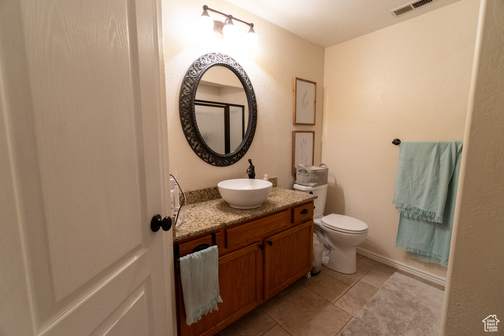 Bathroom with tile patterned flooring, vanity, and toilet