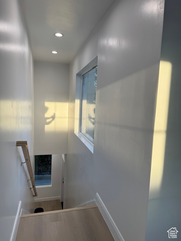 Staircase featuring baseboards, recessed lighting, and wood finished floors