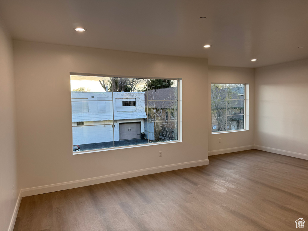 Unfurnished room featuring baseboards, a wealth of natural light, recessed lighting, and wood finished floors