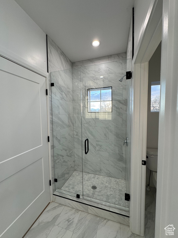 Bathroom featuring toilet, marble finish floor, recessed lighting, and plenty of natural light