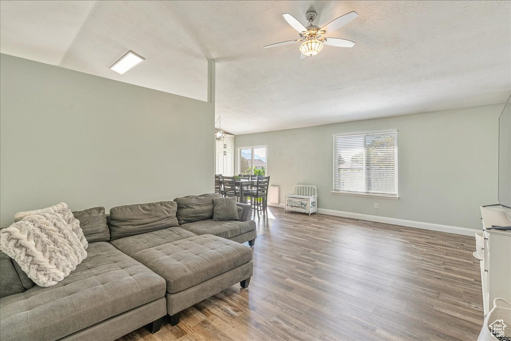 Living room with ceiling fan and hardwood / wood-style floors