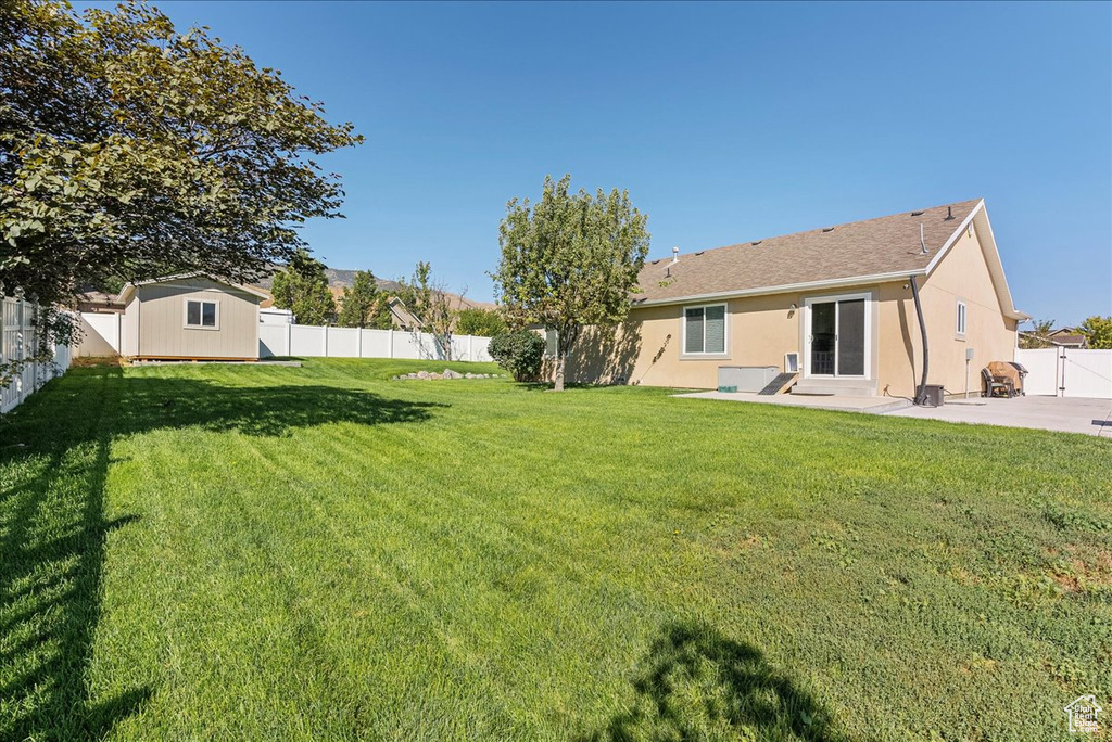 View of yard with a storage unit and a patio