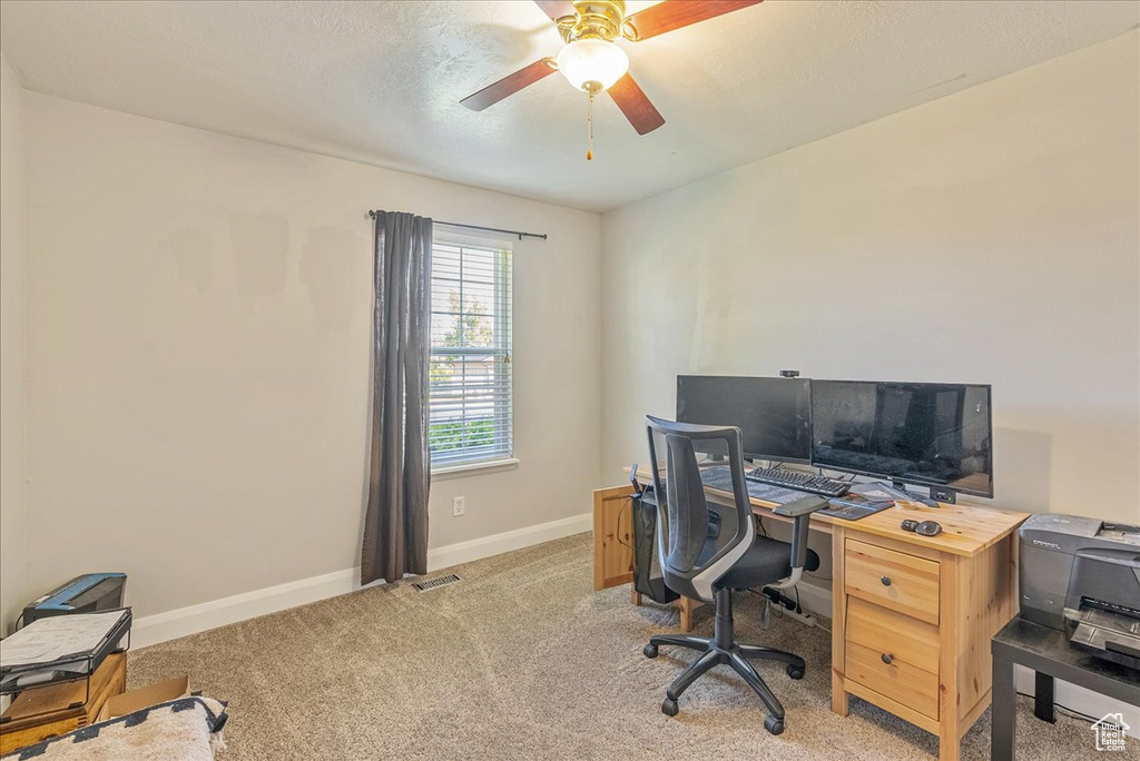 Home office featuring ceiling fan and light colored carpet