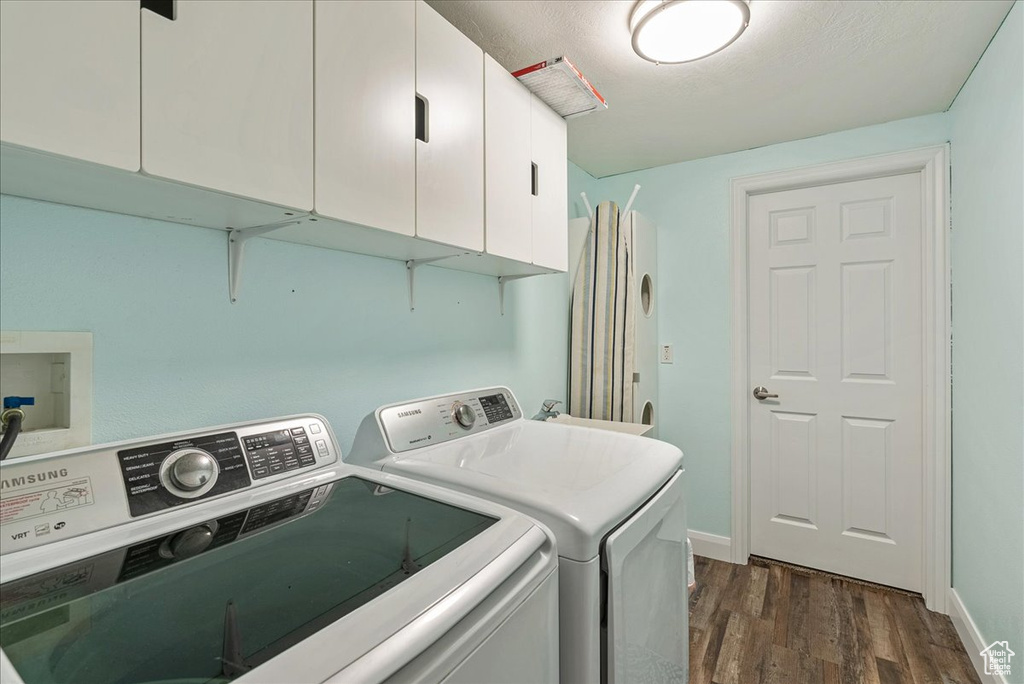 Laundry area featuring dark hardwood / wood-style floors, cabinets, and separate washer and dryer