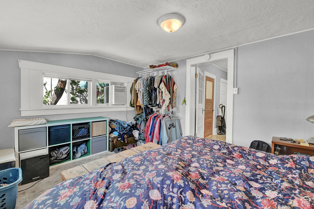 Bedroom with a textured ceiling and lofted ceiling