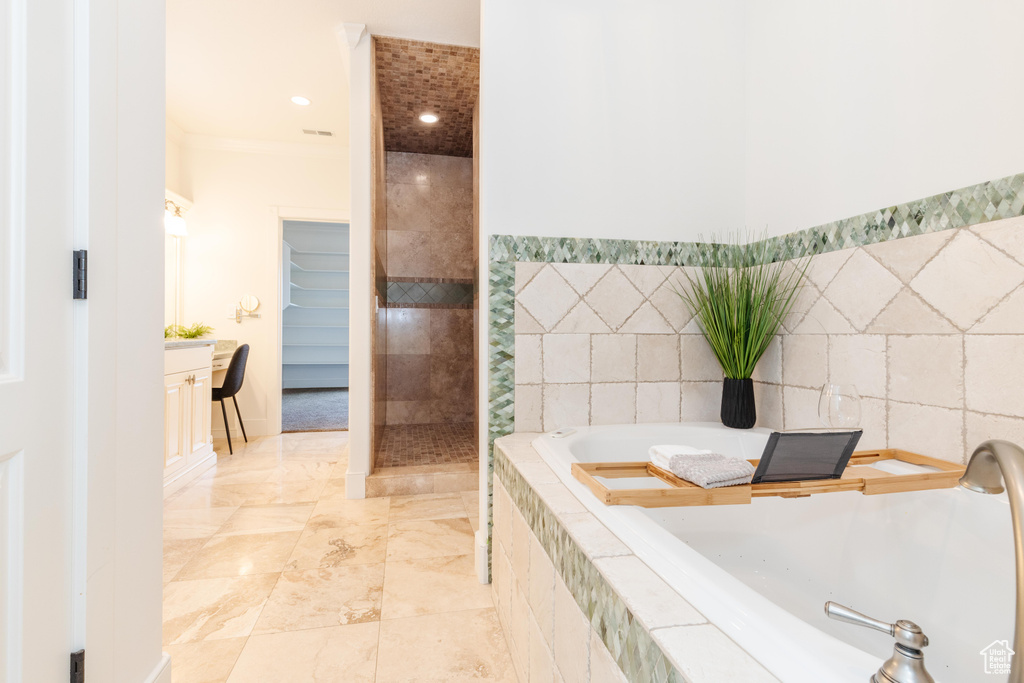 Bathroom featuring tile patterned flooring, tile walls, crown molding, and plus walk in shower