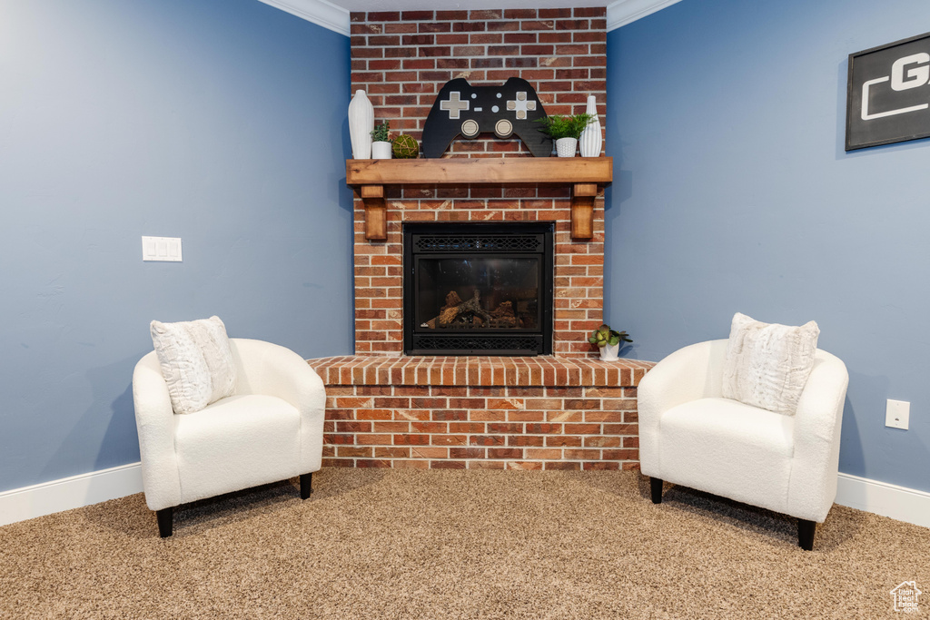 Sitting room with carpet floors, ornamental molding, and a brick fireplace