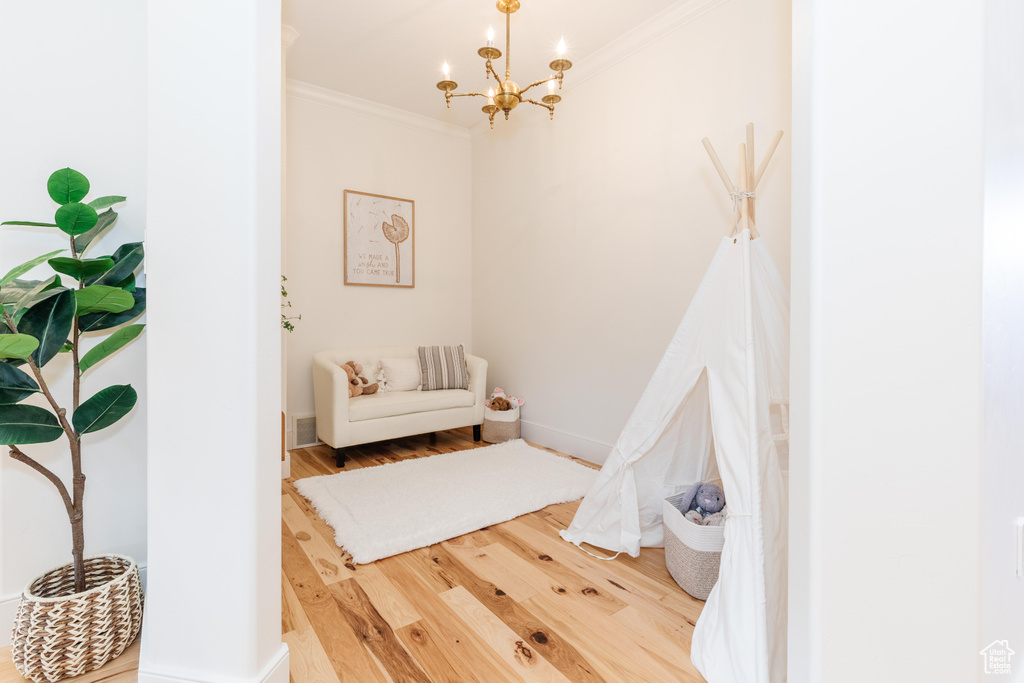 Bedroom featuring crown molding, wood-type flooring, and a chandelier