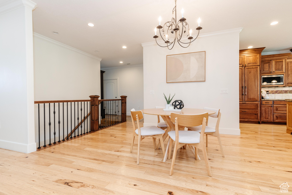 Dining room featuring crown molding, a chandelier, and light wood-type flooring