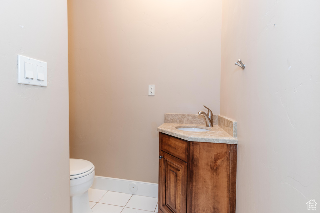 Bathroom featuring tile patterned flooring, toilet, and vanity