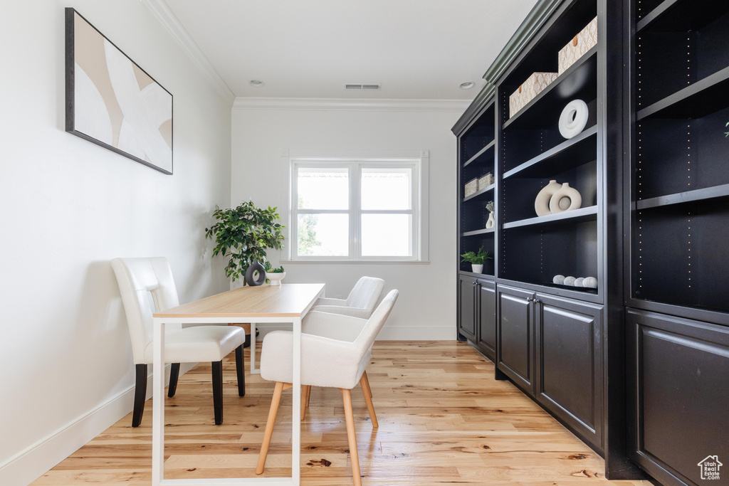 Home office featuring light wood-type flooring and ornamental molding