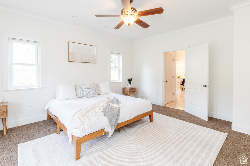 Bedroom featuring ceiling fan, light carpet, and crown molding