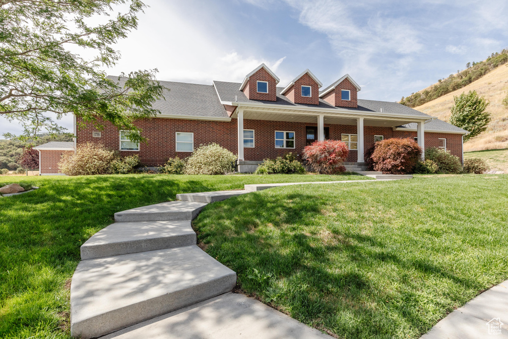 Cape cod house featuring a front lawn