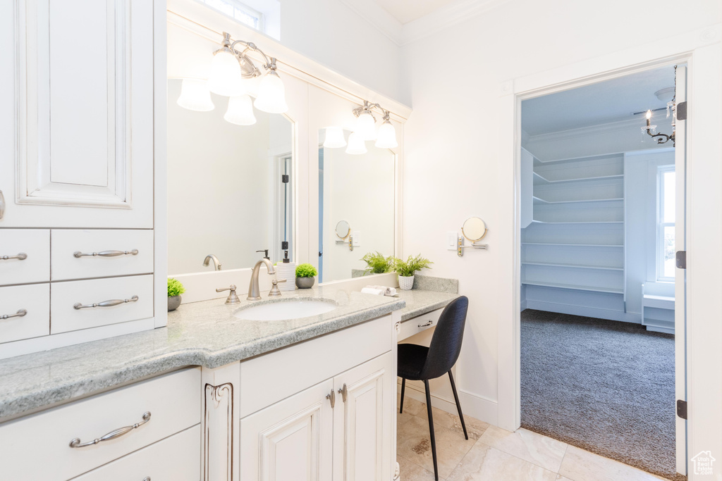 Bathroom with tile patterned flooring, ornamental molding, and vanity