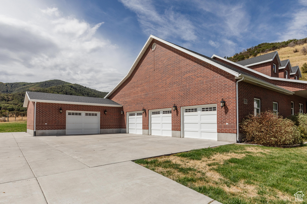 View of home\'s exterior featuring a mountain view, a yard, and a garage