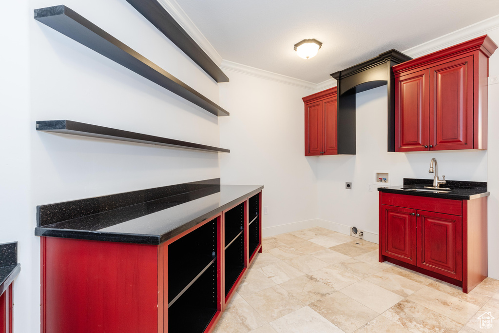 Kitchen featuring sink, crown molding, and light tile patterned floors