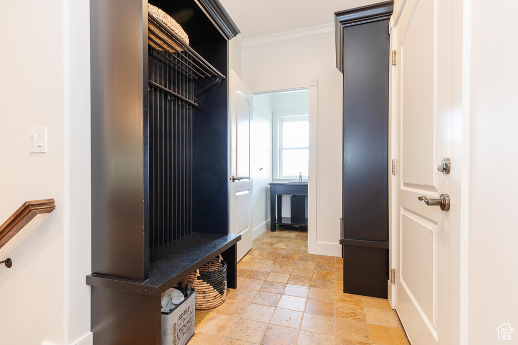 Mudroom with crown molding and light tile patterned flooring