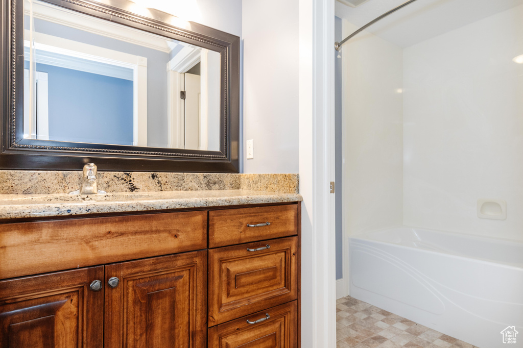 Bathroom featuring shower / bathtub combination, tile patterned flooring, and vanity