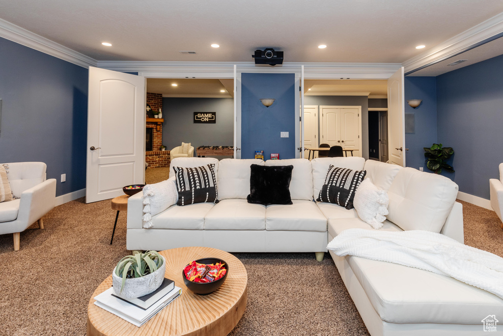 Living room with a fireplace, ornamental molding, and carpet flooring