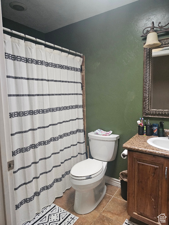 Bathroom with tile patterned flooring, toilet, and vanity