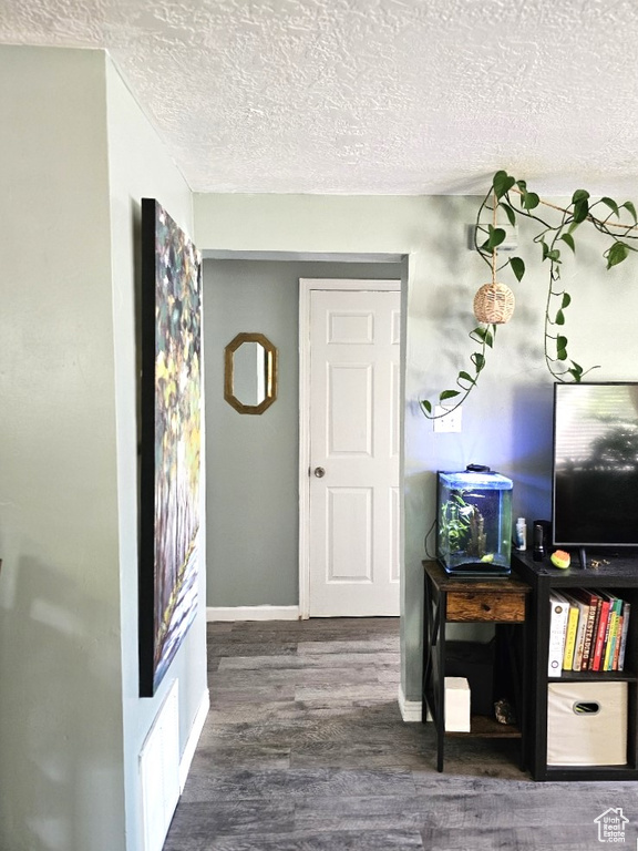 Corridor featuring a textured ceiling and hardwood / wood-style flooring