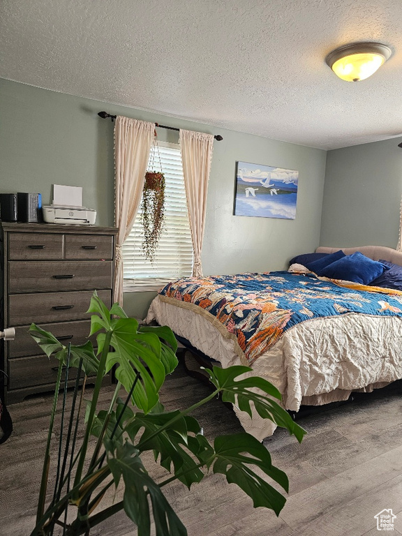 Bedroom with wood-type flooring and a textured ceiling