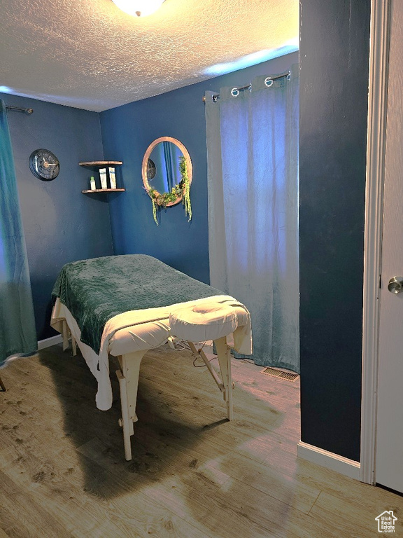 Bedroom featuring wood-type flooring and a textured ceiling