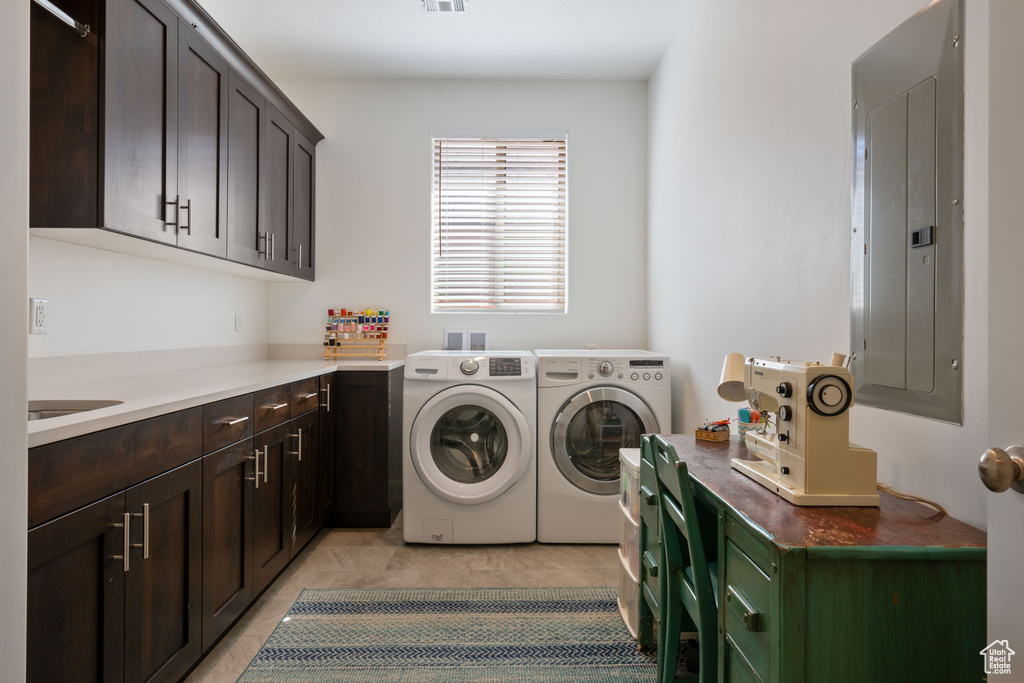 Clothes washing area with light tile patterned flooring, electric panel, separate washer and dryer, and cabinets