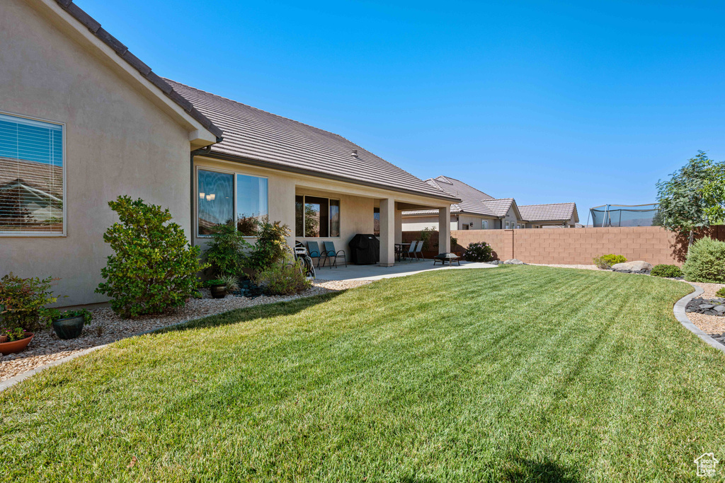 Back of house featuring a lawn and a patio area