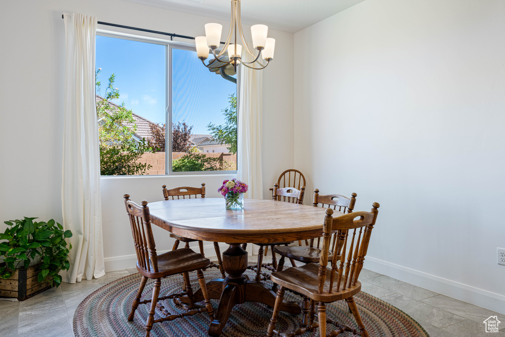 Tiled dining area with a notable chandelier and plenty of natural light