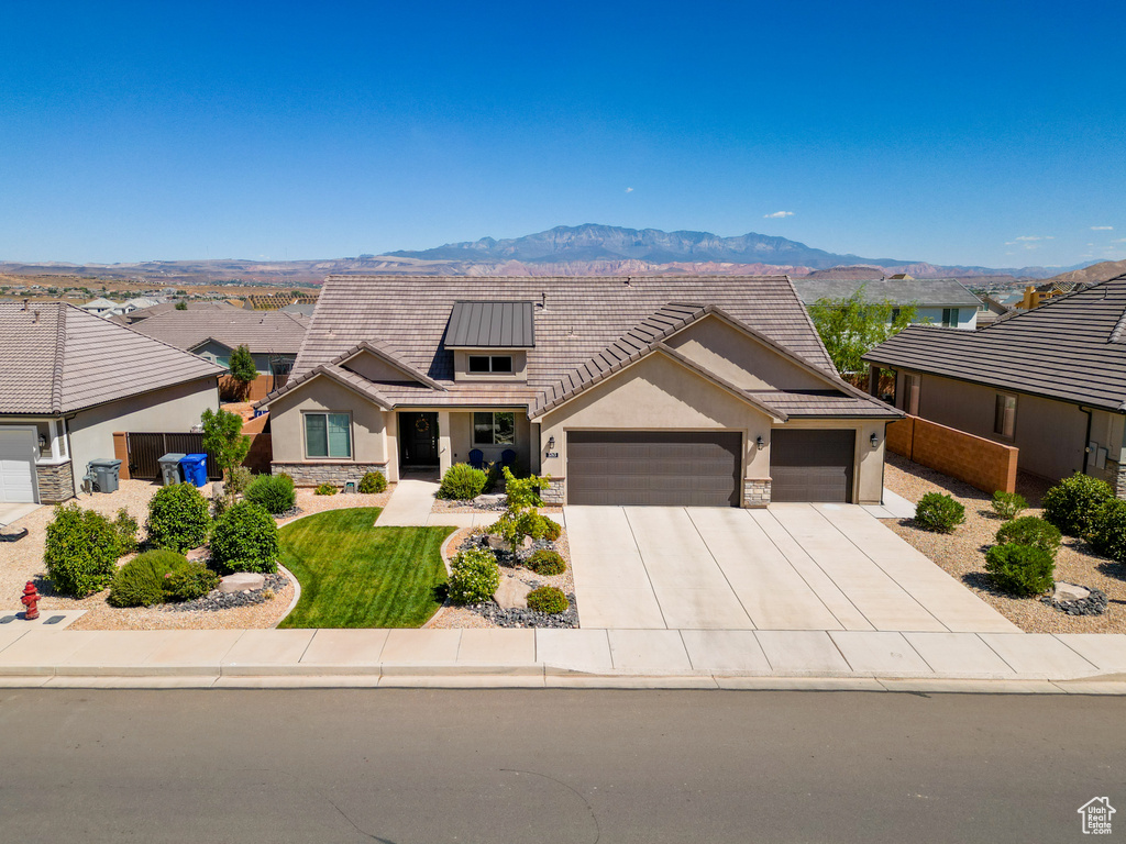 View of front of house with a mountain view and a garage