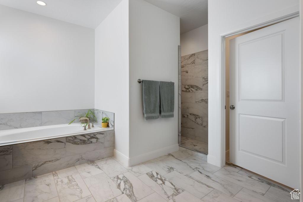 Bathroom featuring tile patterned flooring and a relaxing tiled tub