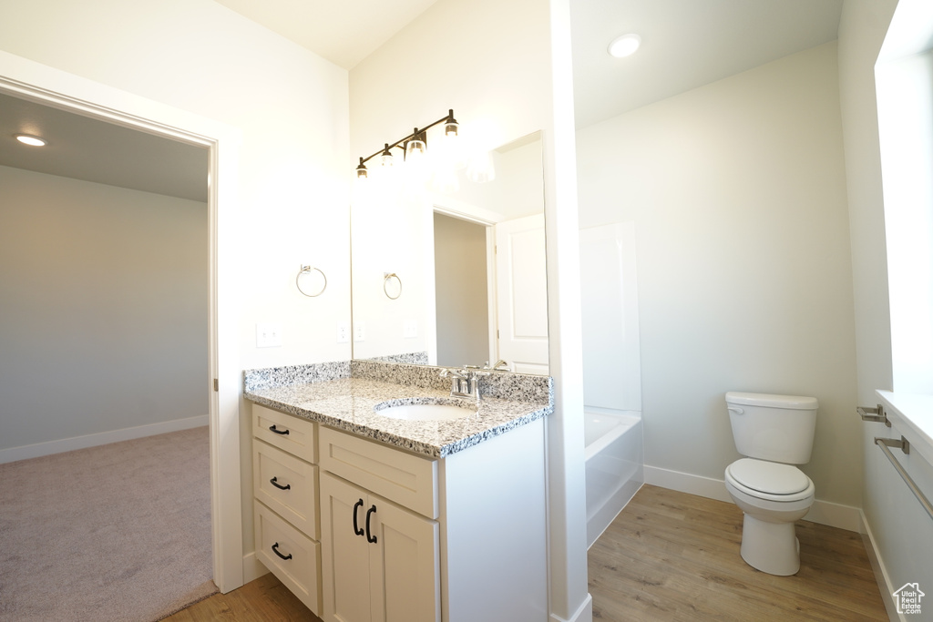 Bathroom with toilet, vanity, and hardwood / wood-style flooring