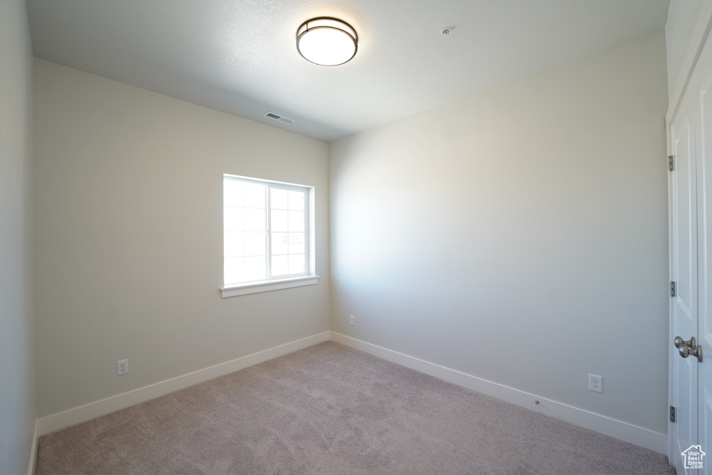 Empty room with light colored carpet