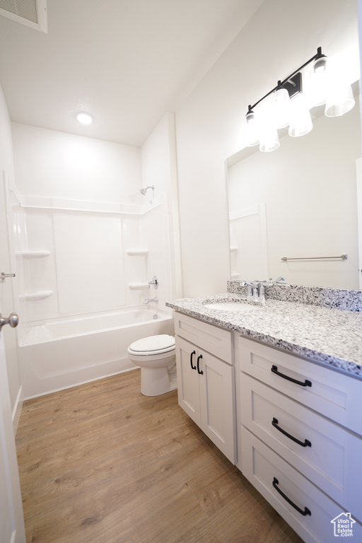 Full bathroom featuring shower / bathtub combination, toilet, hardwood / wood-style flooring, and vanity