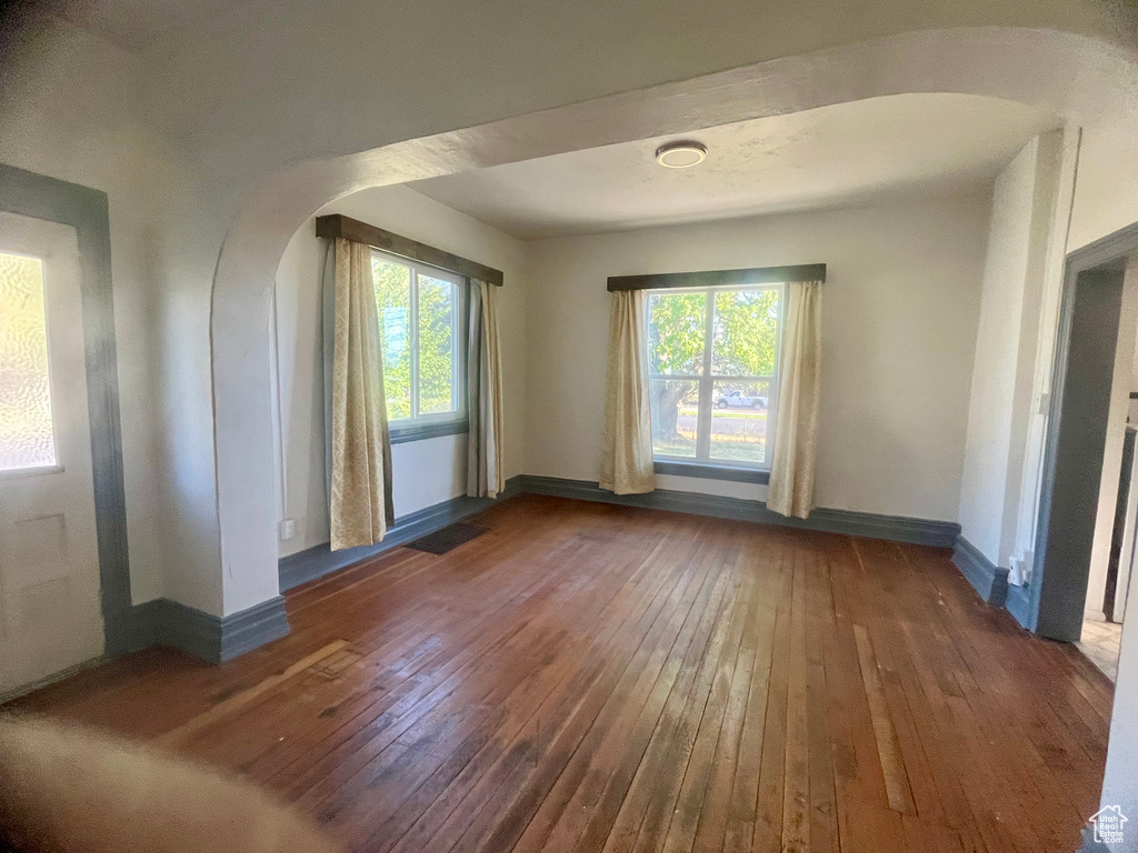 Unfurnished room with a wealth of natural light and dark hardwood / wood-style floors