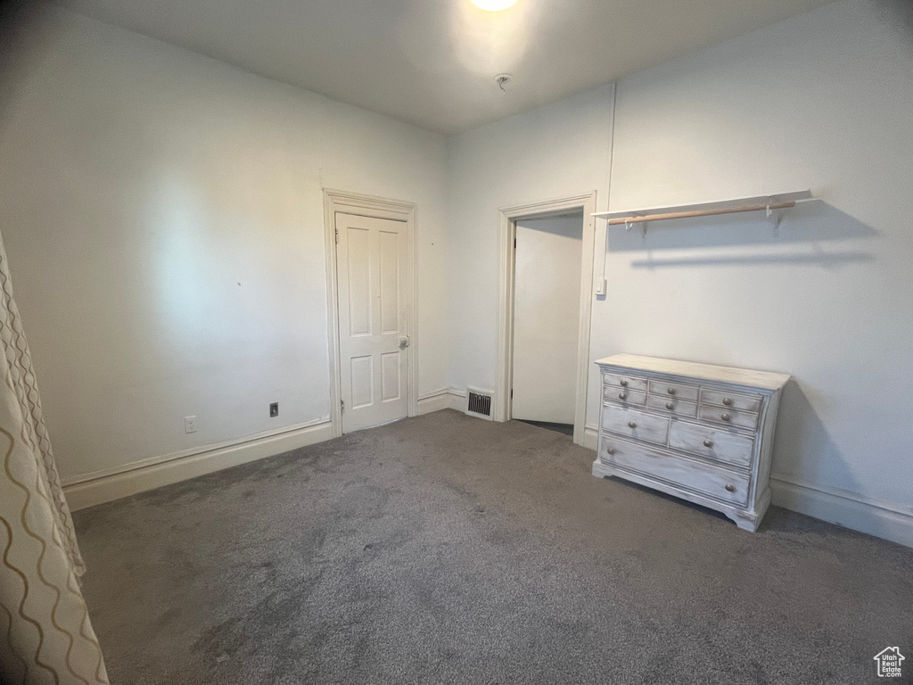 Unfurnished bedroom featuring dark colored carpet