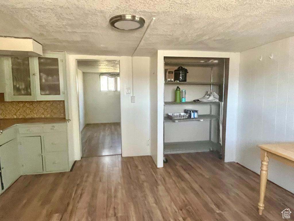 Kitchen with a textured ceiling and hardwood / wood-style floors