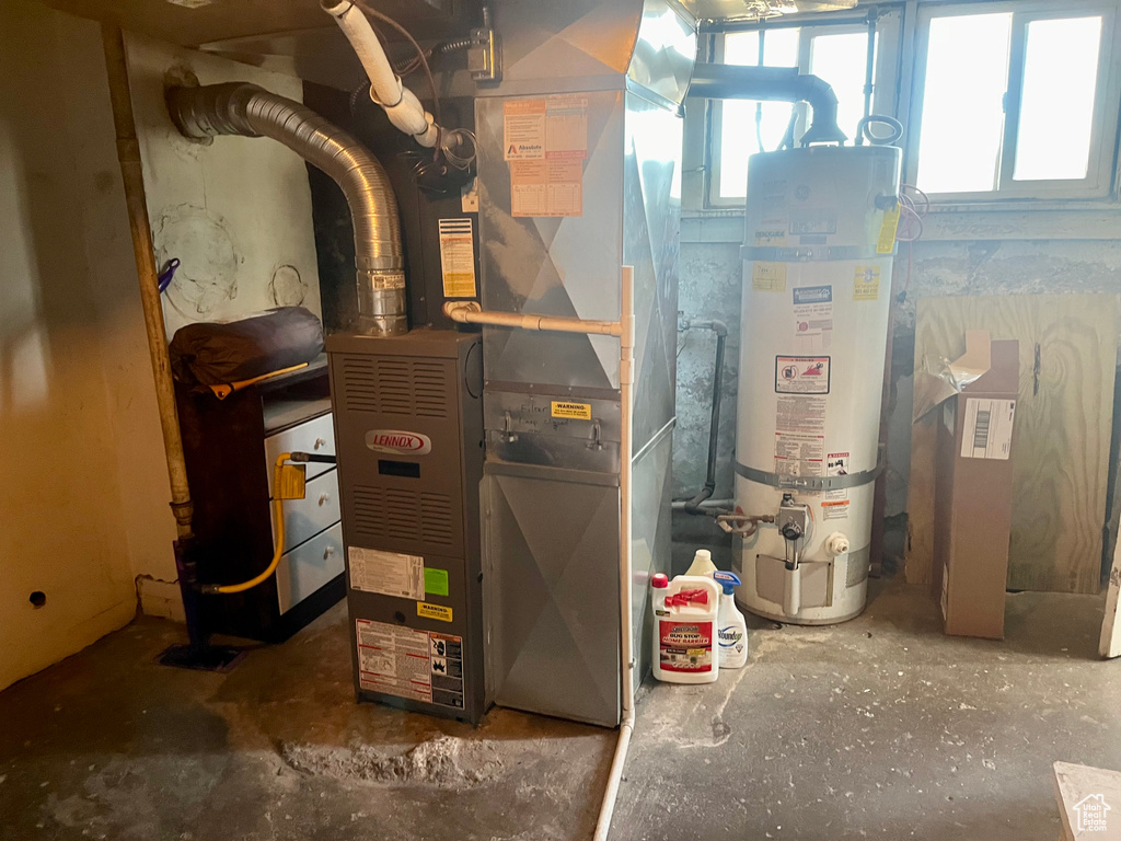 Utility room featuring secured water heater and heating unit