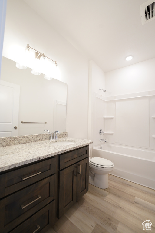 Full bathroom featuring bathtub / shower combination, vanity, hardwood / wood-style floors, and toilet