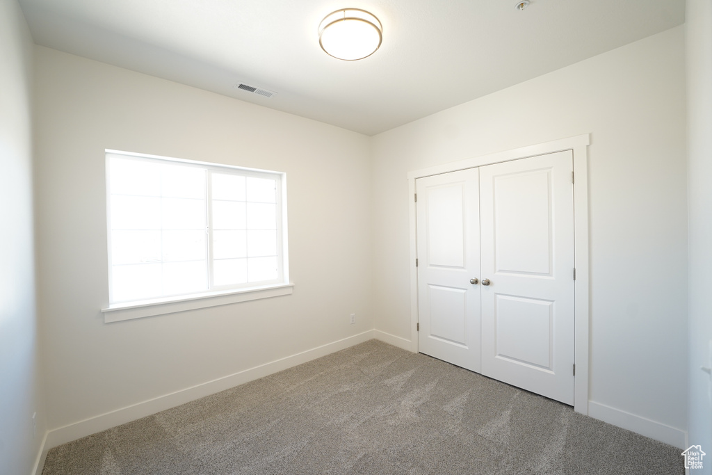 Unfurnished bedroom featuring carpet and a closet