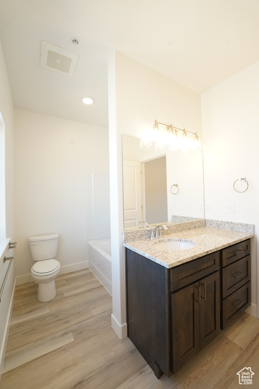 Full bathroom with shower / bathing tub combination, wood-type flooring, vanity, and toilet