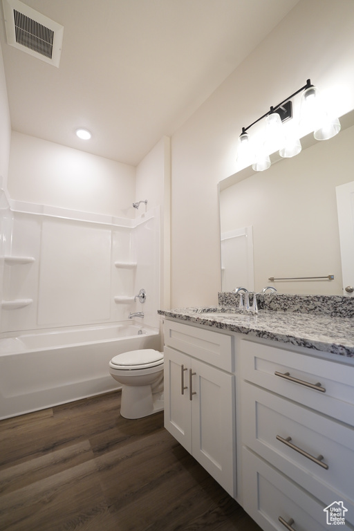 Full bathroom featuring toilet, vanity, bathing tub / shower combination, and wood-type flooring