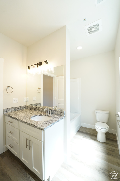 Full bathroom with shower / bath combination, hardwood / wood-style flooring, toilet, and vanity