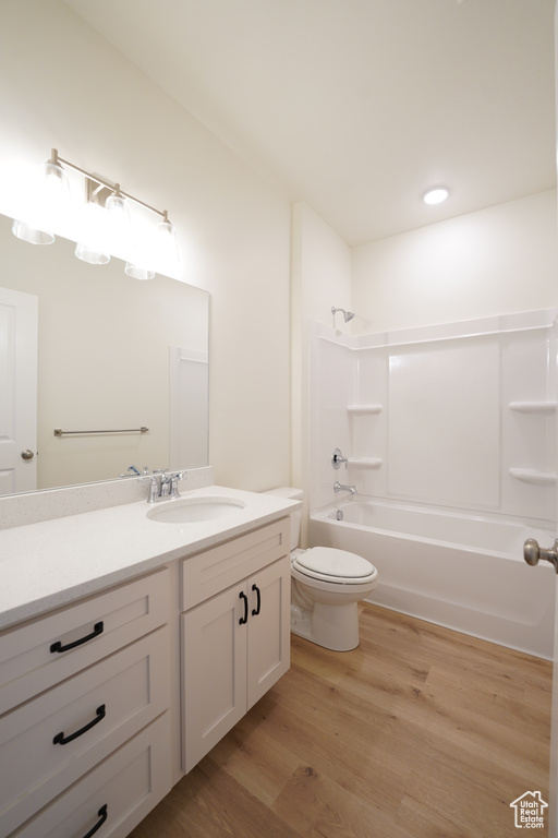 Full bathroom featuring bathing tub / shower combination, toilet, hardwood / wood-style floors, and vanity