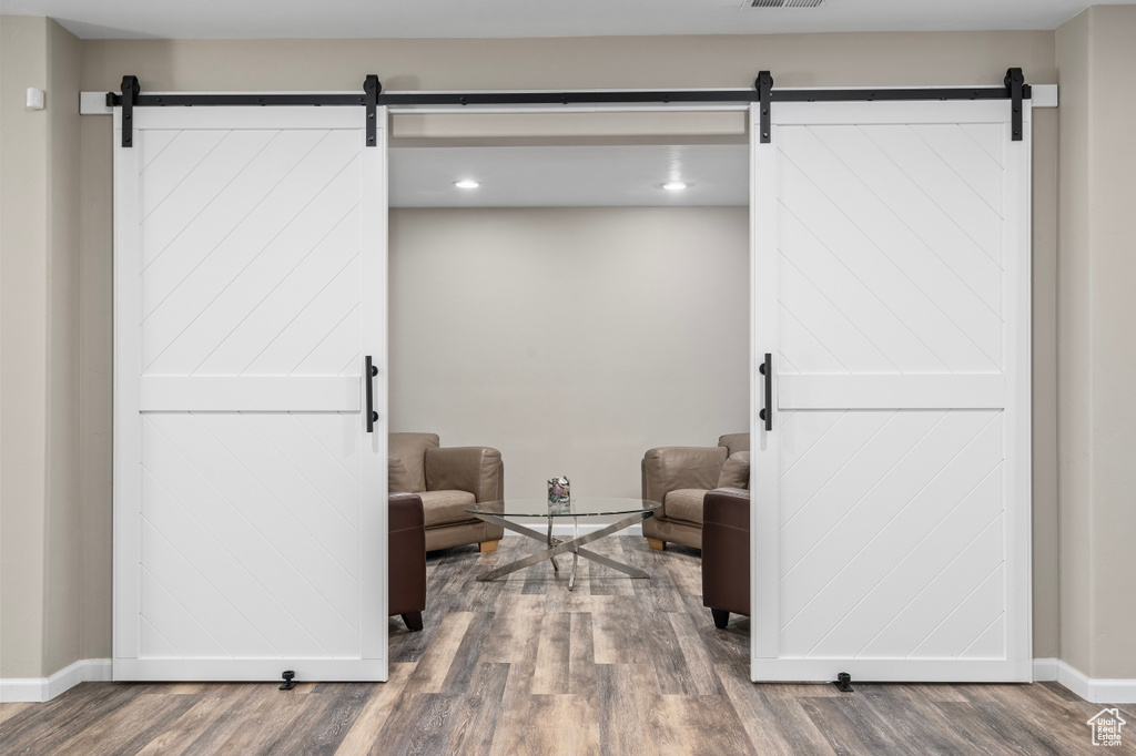 Sitting room with a barn door and hardwood / wood-style flooring