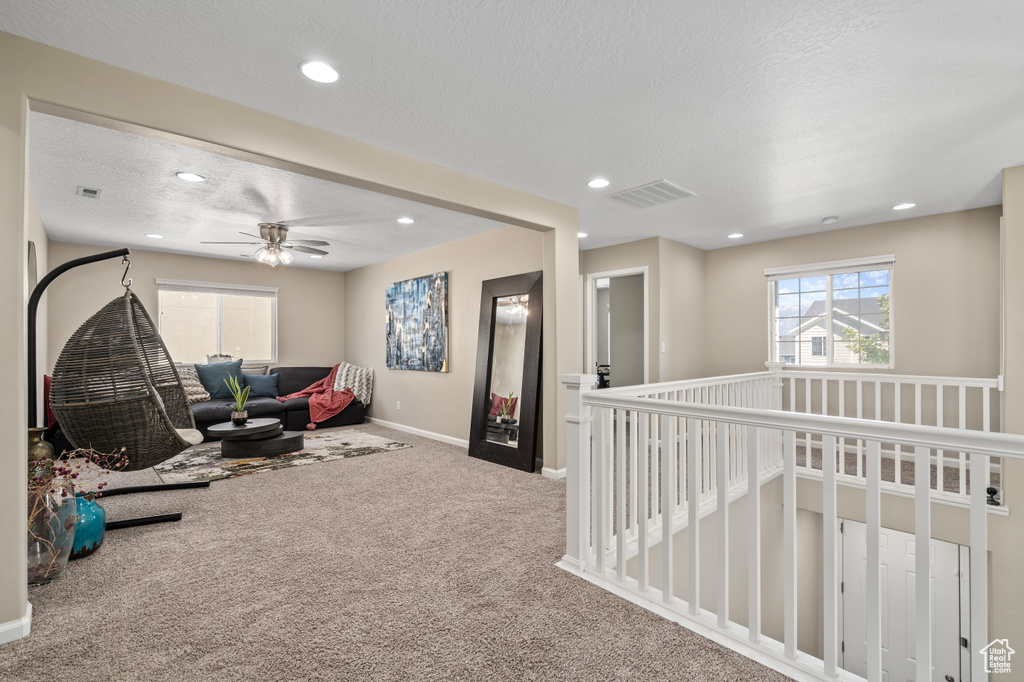 Interior space featuring ceiling fan, carpet flooring, and a textured ceiling