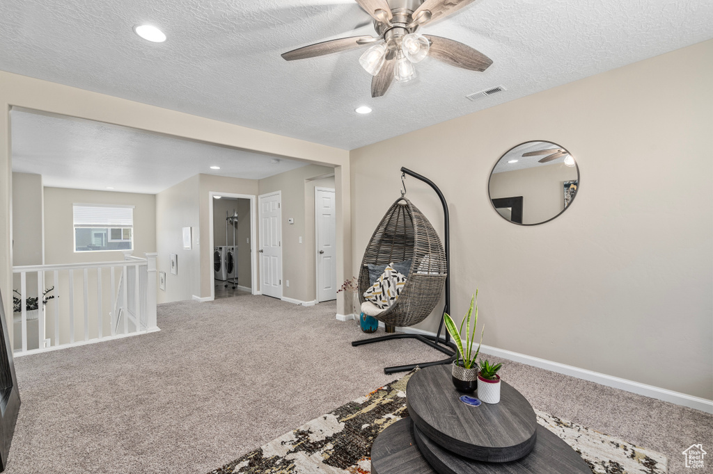 Interior space with carpet floors, a textured ceiling, and ceiling fan