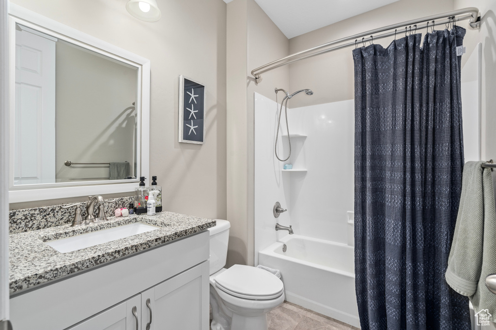 Full bathroom with toilet, vanity, shower / bath combo, and tile patterned floors